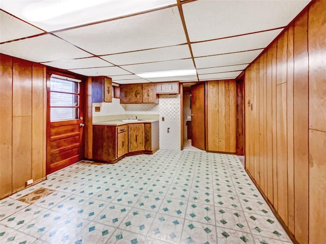 1 Charter Ln, Smithtown, NY 11787 - kitchen with wooden walls, brown cabinets, light floors, and a sink