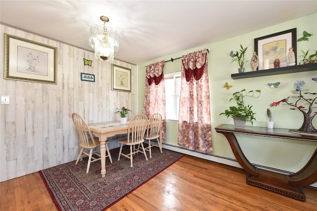 dining space featuring hardwood / wood-style floors and a notable chandelier