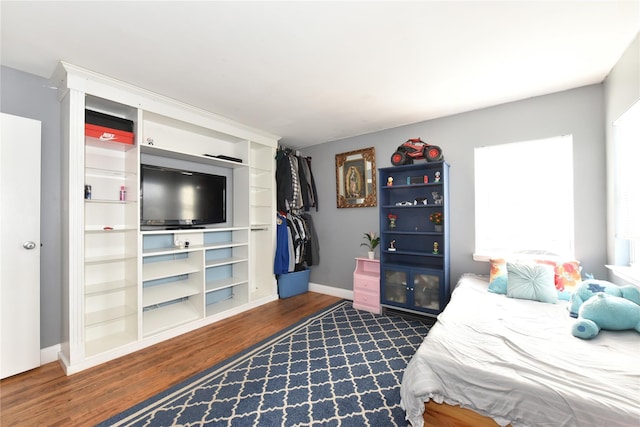 bedroom with baseboards and dark wood-style flooring