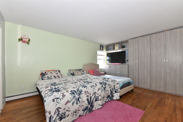 bedroom featuring a baseboard heating unit and wood finished floors