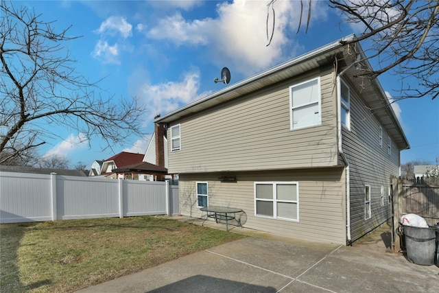 rear view of property with a yard, a patio area, and a fenced backyard