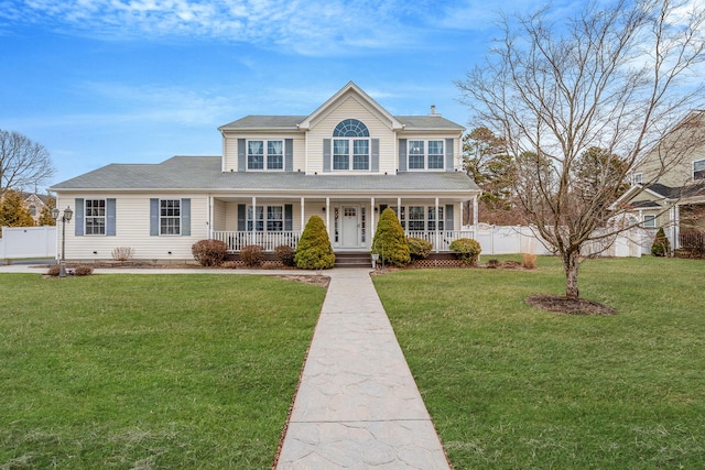 colonial-style house featuring a porch, a chimney, a front yard, and fence