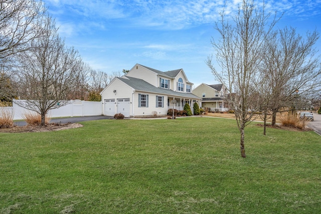 view of front of home featuring fence, a front yard, covered porch, a garage, and driveway