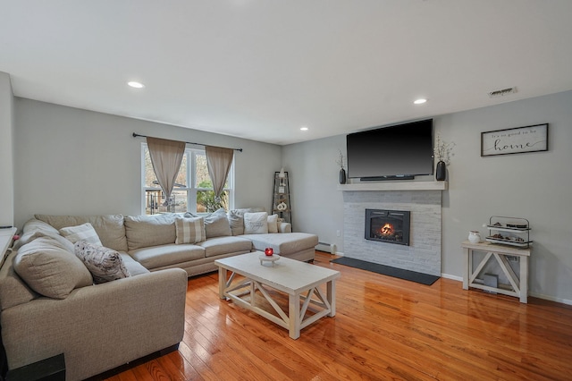 living room with visible vents, light wood-style flooring, recessed lighting, a fireplace, and baseboard heating