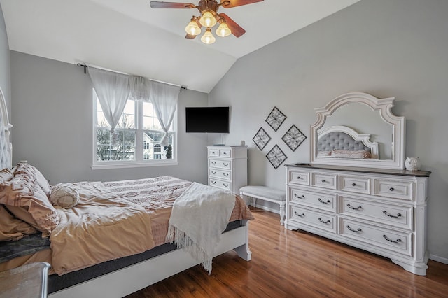 bedroom with a ceiling fan, lofted ceiling, and wood finished floors