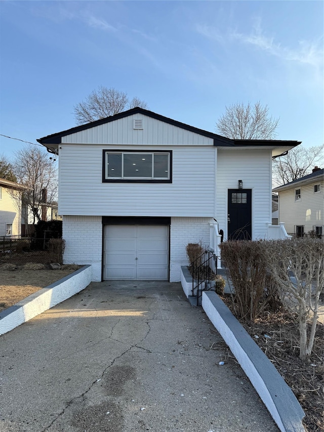 view of front of home featuring an attached garage, brick siding, and driveway