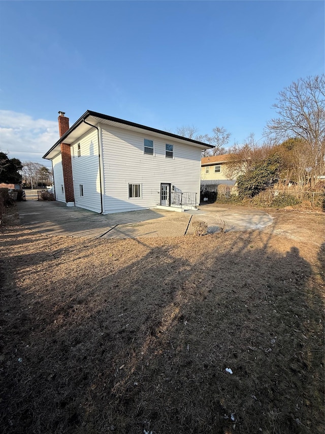 back of house with a chimney and a patio area