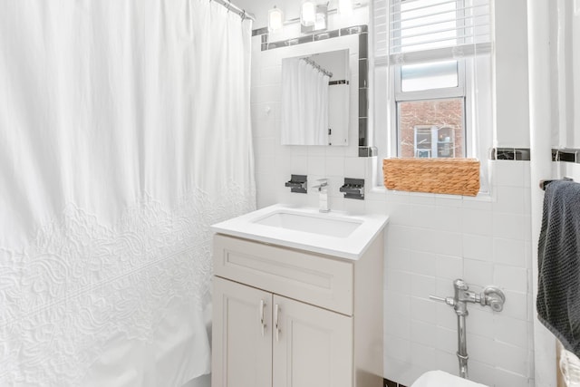 full bath with tile walls and vanity