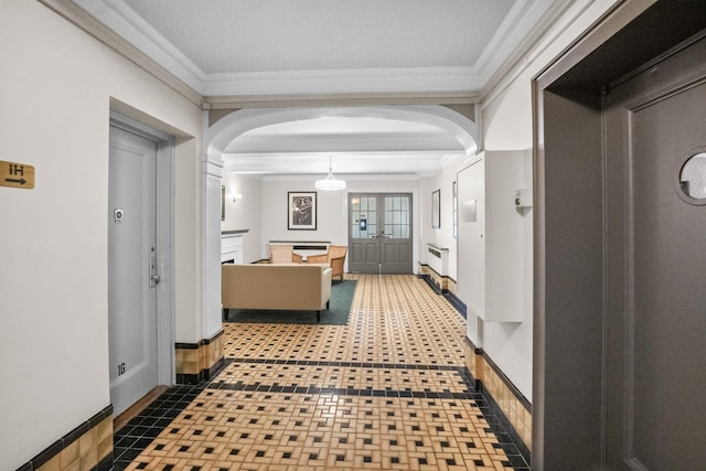 corridor featuring arched walkways, crown molding, and baseboards