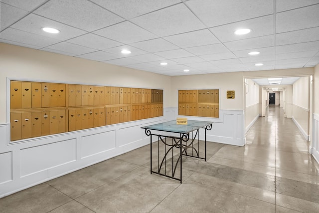 playroom with recessed lighting, mail area, a paneled ceiling, and a decorative wall