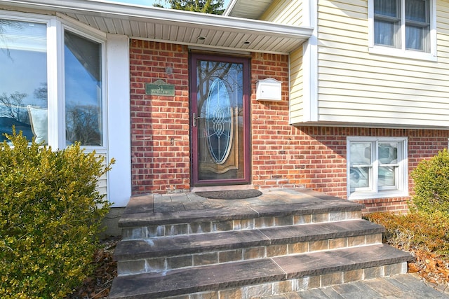 doorway to property featuring brick siding