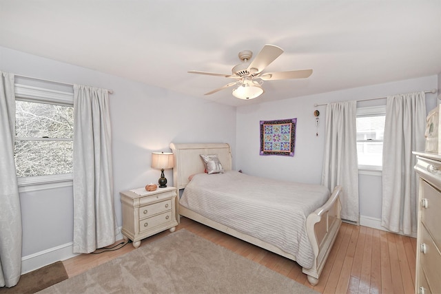 bedroom featuring baseboards, light wood-type flooring, and ceiling fan