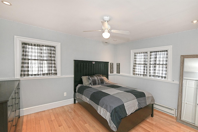 bedroom featuring wood finished floors, baseboards, a ceiling fan, recessed lighting, and a baseboard heating unit