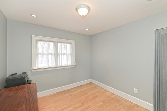 empty room with recessed lighting, light wood-type flooring, and baseboards