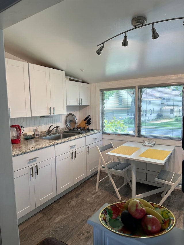 kitchen featuring backsplash, dark wood finished floors, lofted ceiling, white cabinets, and a sink