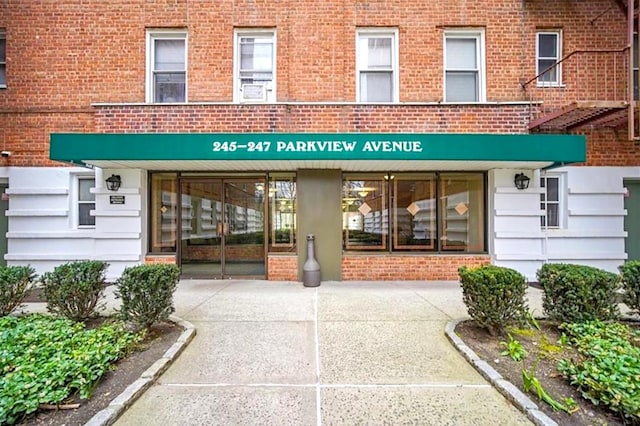 view of exterior entry featuring brick siding