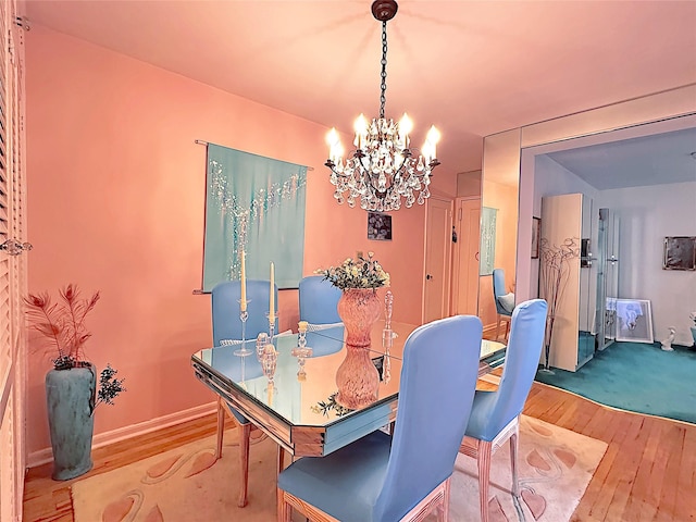 dining area with an inviting chandelier, wood finished floors, and baseboards