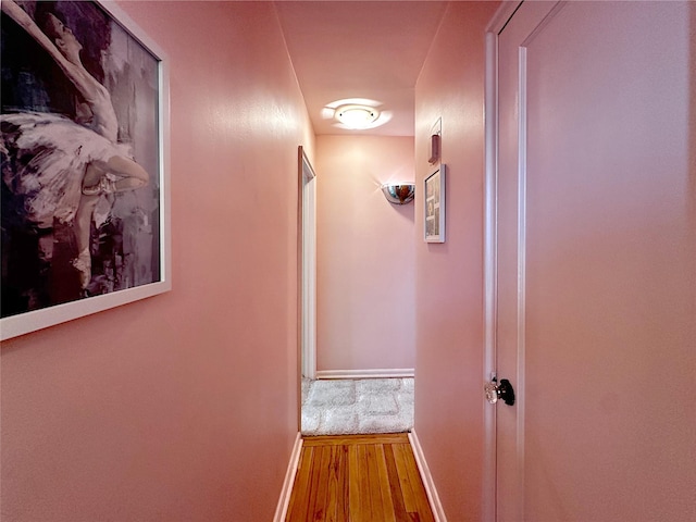 hallway featuring baseboards and wood finished floors