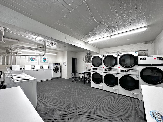 shared laundry area with stacked washer / dryer and washing machine and clothes dryer