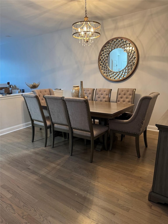 dining area with a chandelier, baseboards, and wood finished floors