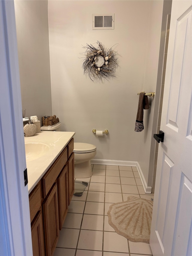 bathroom with vanity, visible vents, baseboards, tile patterned flooring, and toilet