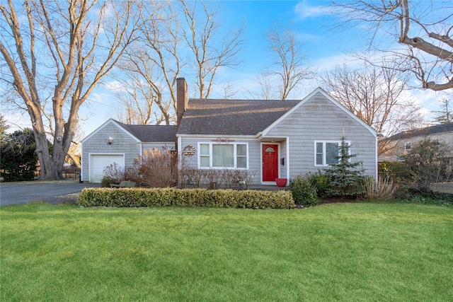 view of front of house featuring a garage, a chimney, a front yard, and aphalt driveway