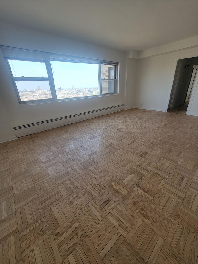 empty room featuring a baseboard radiator and baseboards