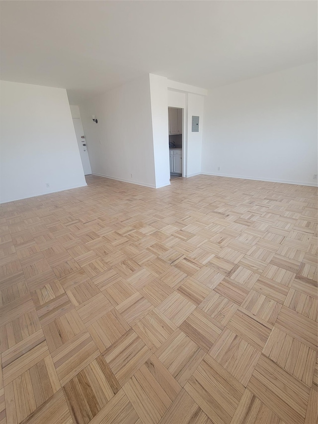 unfurnished room featuring baseboards and electric panel