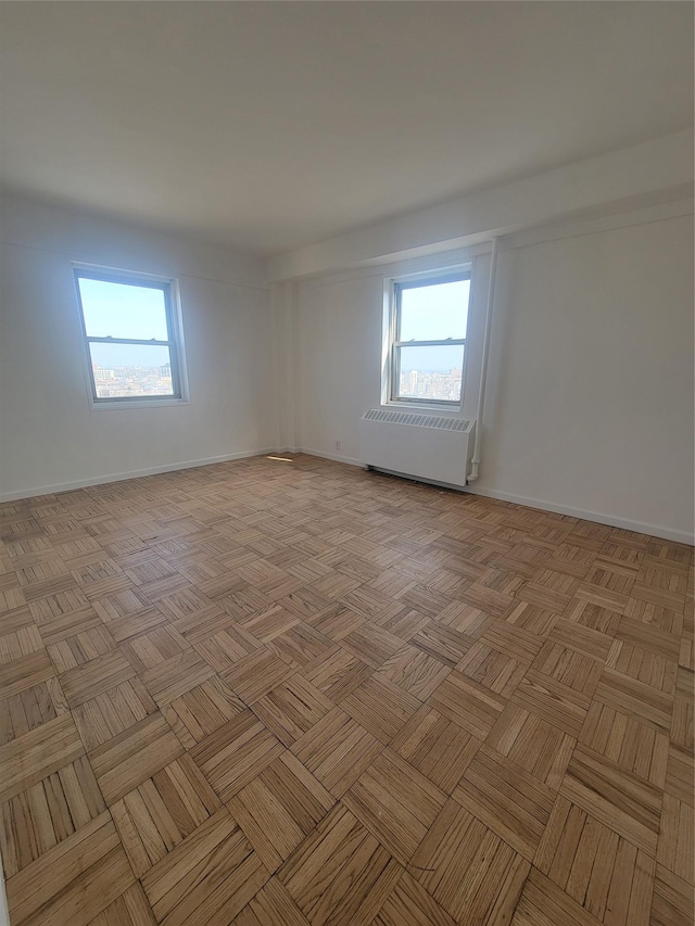 spare room featuring baseboards and plenty of natural light