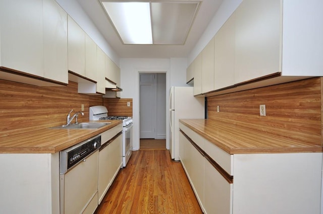 kitchen with white cabinetry, white appliances, decorative backsplash, and a sink