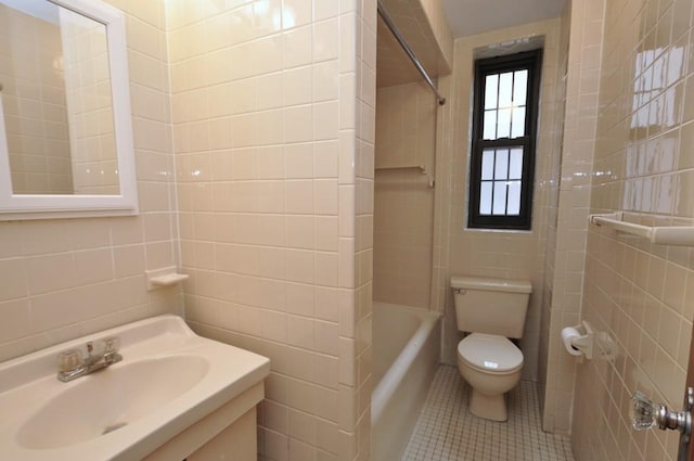 bathroom with vanity,  shower combination, tile walls, toilet, and tile patterned floors