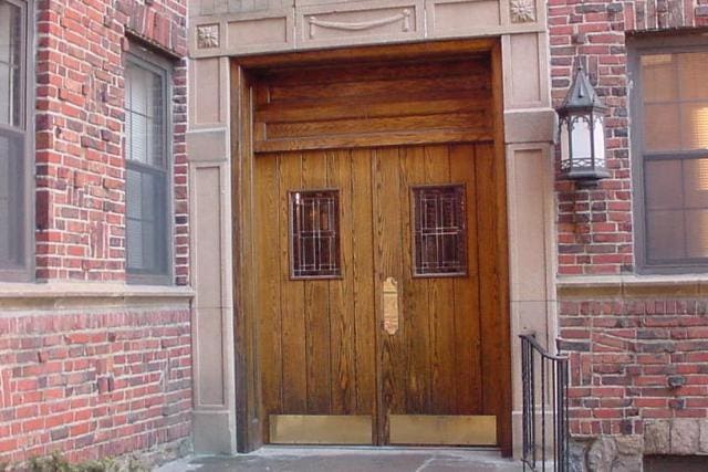 view of exterior entry featuring brick siding