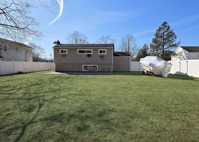 back of house featuring a yard, a fenced backyard, a chimney, and a gate