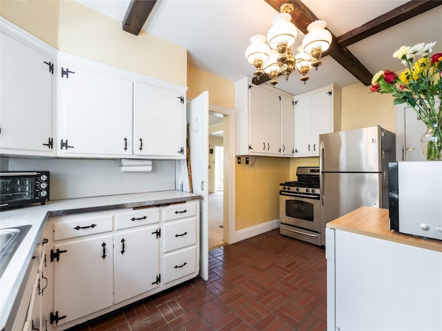 679 Saint Lukes Pl, Baldwin, NY 11510 - kitchen featuring appliances with stainless steel finishes, brick flooring, a chandelier, baseboards, and white cabinetry