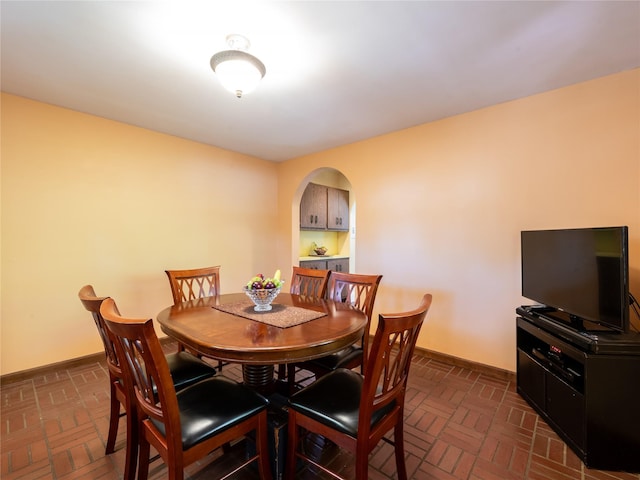 679 Saint Lukes Pl, Baldwin, NY 11510 - dining space with brick floors, baseboards, and arched walkways