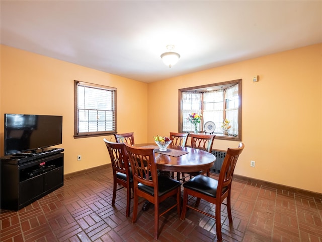 679 Saint Lukes Pl, Baldwin, NY 11510 - dining space featuring plenty of natural light, brick patterned floors, and baseboards