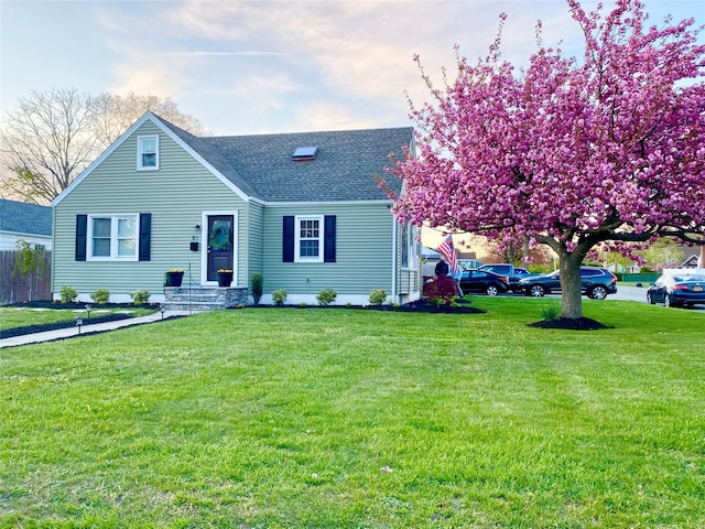 view of front of property with a front lawn and roof with shingles