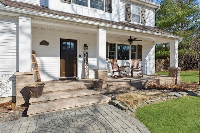 view of exterior entry featuring a porch, a ceiling fan, and board and batten siding