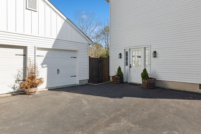 garage with driveway and fence