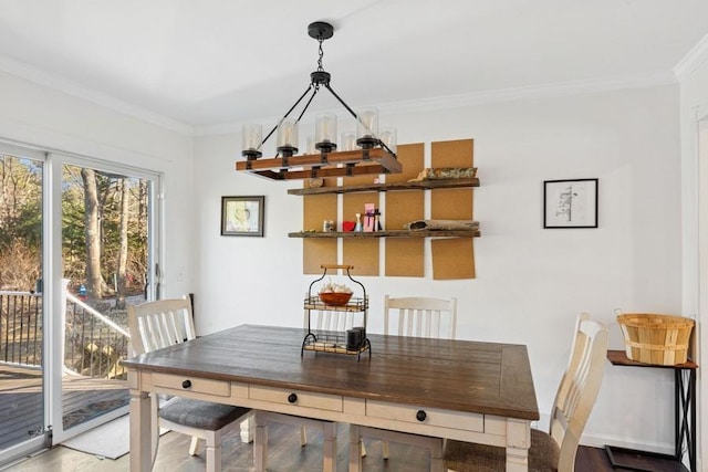 dining space featuring crown molding, wood finished floors, and baseboards