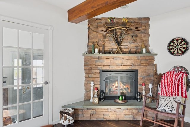 interior details featuring a stone fireplace, beamed ceiling, and wood finished floors