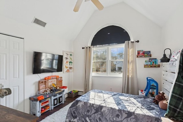 bedroom featuring wood finished floors, visible vents, lofted ceiling, ceiling fan, and a closet