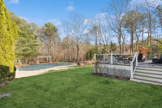 view of yard featuring a wooden deck and a view of trees