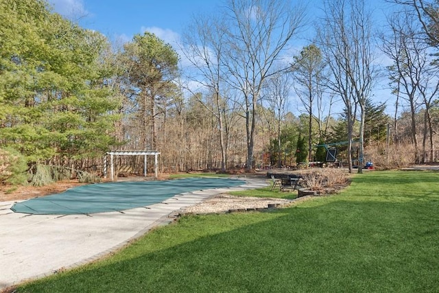 view of swimming pool with a yard and a pergola