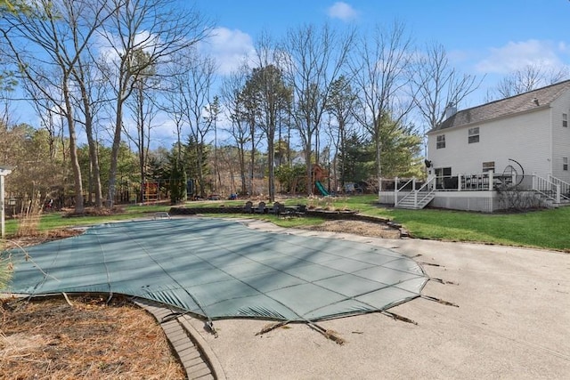 view of swimming pool with a yard and a wooden deck