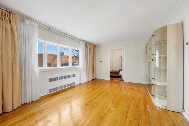 interior space featuring stairs, light wood-style flooring, radiator, and baseboards