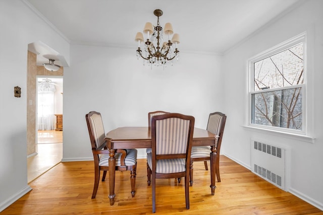 dining area with light wood-type flooring, plenty of natural light, radiator, and crown molding