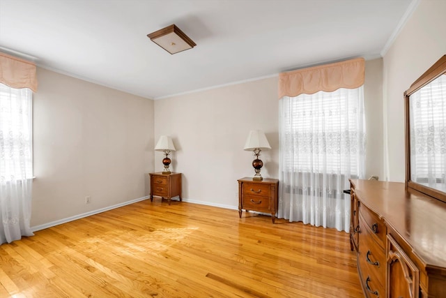 interior space with light wood finished floors, baseboards, and ornamental molding