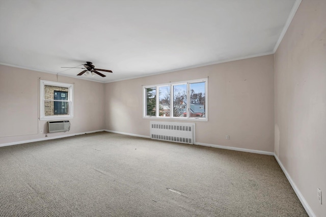 carpeted spare room featuring a wall unit AC, baseboards, radiator heating unit, ceiling fan, and ornamental molding