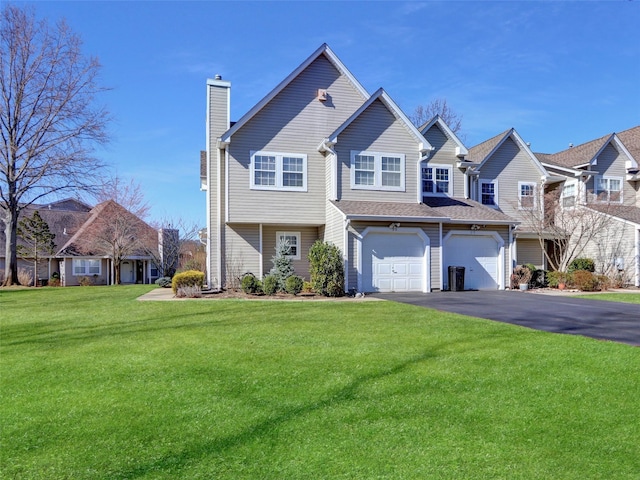 view of front facade featuring driveway, a front lawn, a chimney, and an attached garage